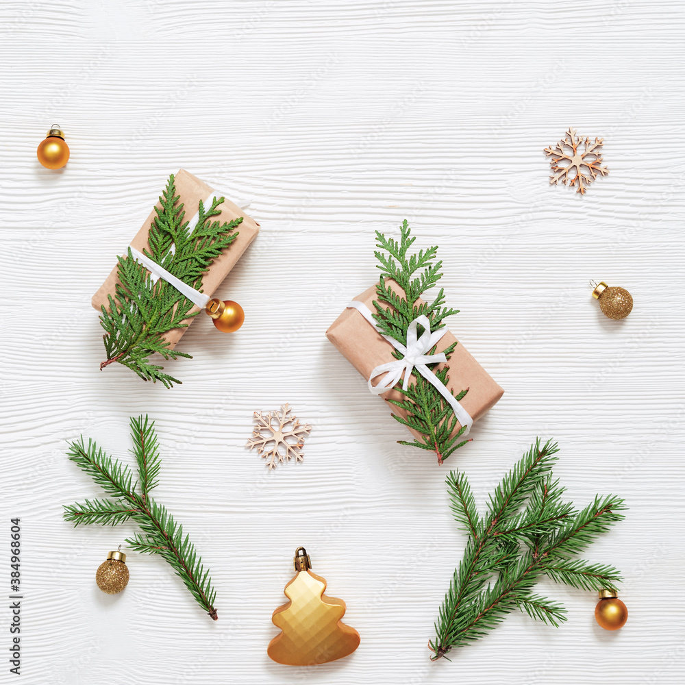 Homemade gift, Christmas present box wrapped in kraft paper, decorated natural green thuja branches, small golden balls Homemade gift, Christmas present box wrapped in kraft paper, decorated natural green thuja branches, small golden balls