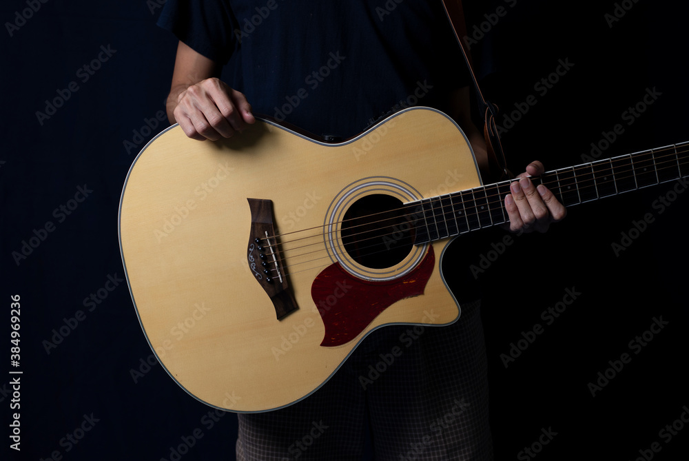 Fototapeta premium Musician at night, Player with an acoustic guitar in the dark, With side lighting.