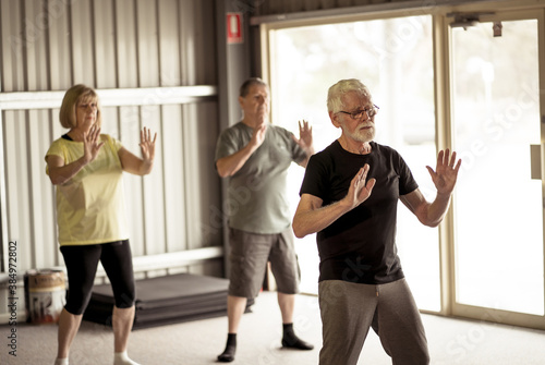 Photos Group of elderly senior people practicing Tai chi class in age care gym facilities