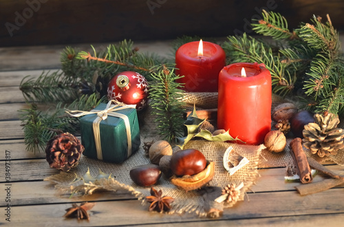 traditional christmas decoration on wooden table with candles and gift box