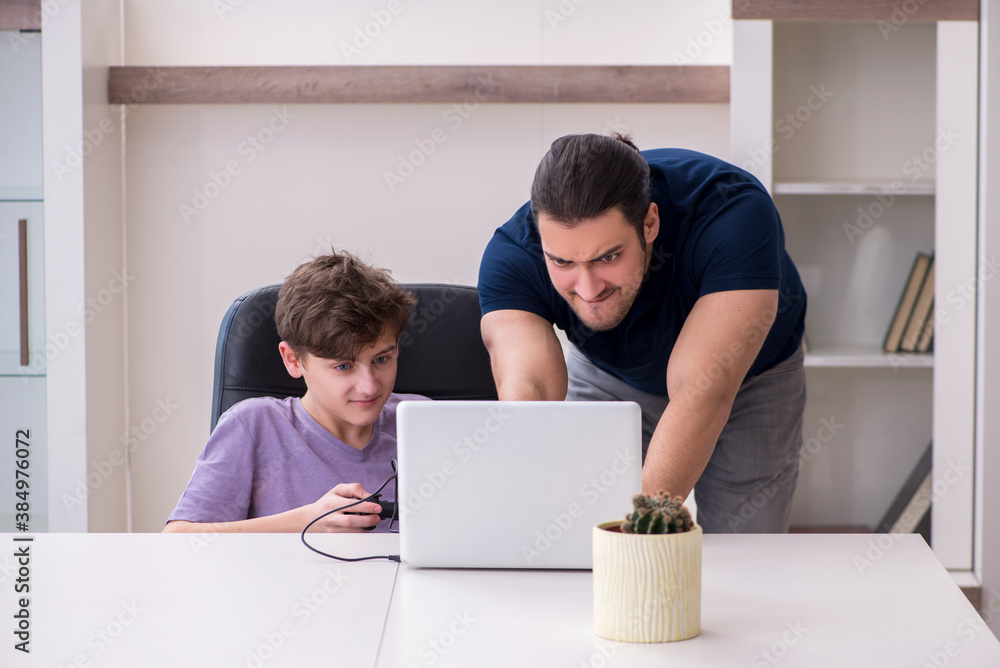 Young father and schoolboy playing computer games at home Young father and schoolboy playing computer games at home