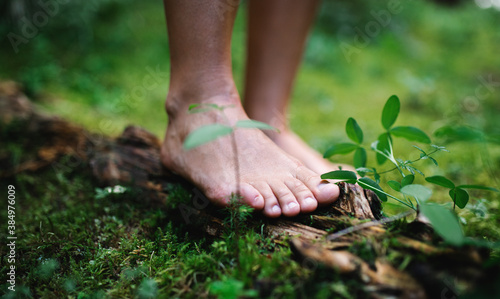 Bare feet of man standing barefoot outdoors in nature, grounding concept. photo