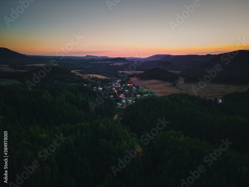 Luftaufnahme von einem Dorf nach Sonnenuntergang in hügeliger Landschaft  © Oskar