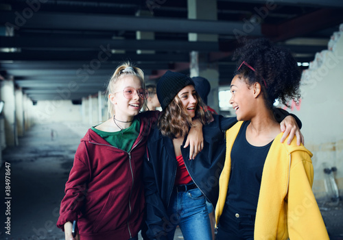 Tableau sur toile Group of teenagers girl gang standing indoors in abandoned building, hanging out