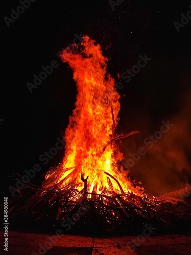 Large yellow orange red flame of hot fire burns in night. Background. Danger. Burning firewood hearth