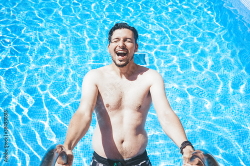 Young handsome man posing near a pool photo