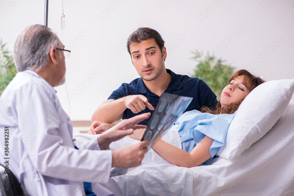 Fototapeta premium Young husband visiting sick wife in the clinic