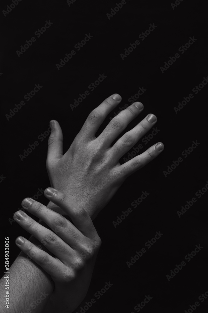 Fototapeta premium men's hands on a dark background close-up