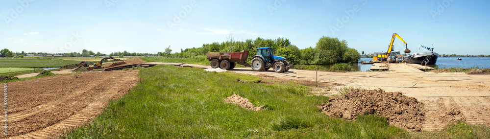 Dike reenforcement by applying a layer of clay; clay is transported from a transportship to the reenfiorcement site by a tracktor. Dike reenforcement by applying a layer of clay; clay is transported from a transportship to the reenfiorcement site by a tracktor.