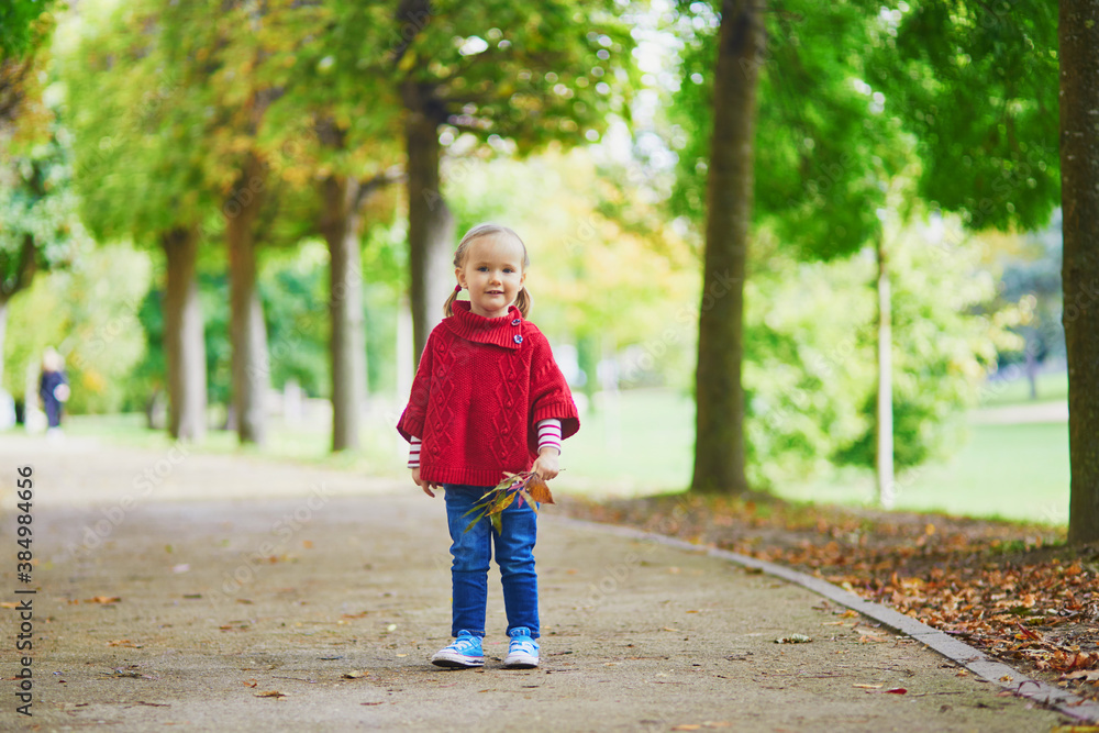 Adorable toddler girl playing in autumn park Adorable toddler girl playing in autumn park
