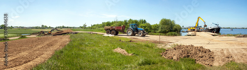 Dike reenforcement by applying a layer of clay  clay is transported from a transportship to the reenfiorcement site by a tracktor.