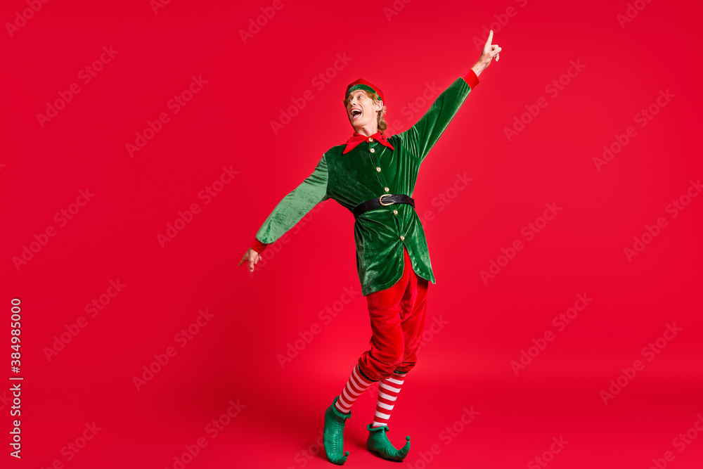 Full body photo of crazy elf dance x-mas christmas tradition party concept wear costume isolated on red shine color background Full body photo of crazy elf dance x-mas christmas tradition party concept wear costume isolated on red shine color background