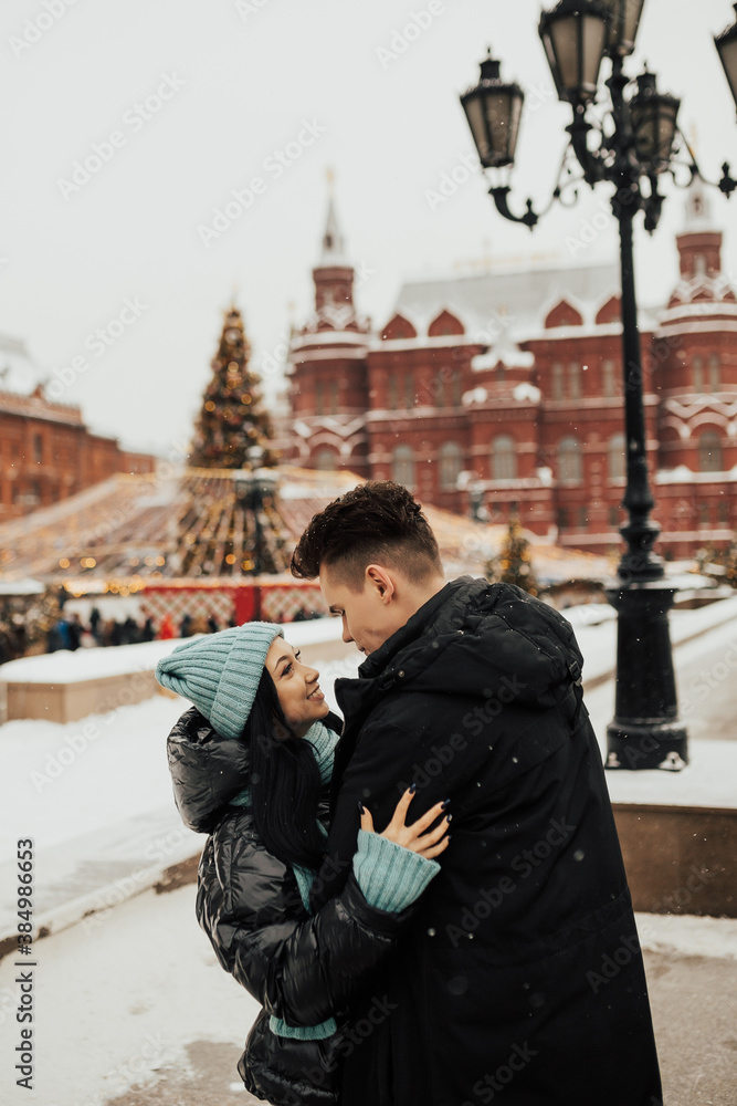 Young lovers enjoy time together on the street in the city, on the winter holidays, romance.