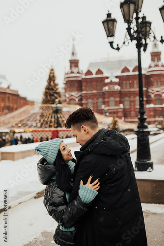 Obraz na płótnie Young lovers enjoy time together on the street in the city, on the winter holidays, romance. w salonie