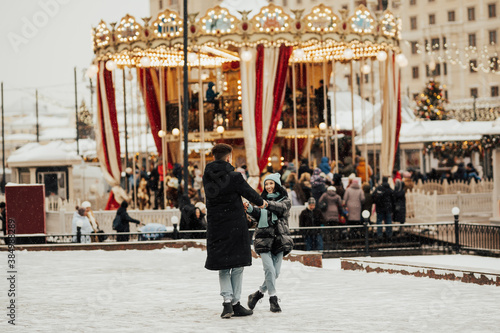 Photography Young romantic couple is having fun outdoors in winter at the amusement park