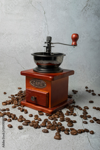 selective focus. manual retro coffee bean mill. dark wood on a light gray background. with Cafe written in metal letters