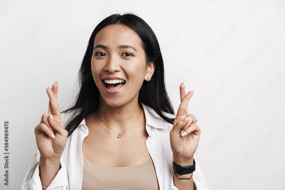 Beautiful happy asian woman smiling while posing with fingers crossed Beautiful happy asian woman smiling while posing with fingers crossed