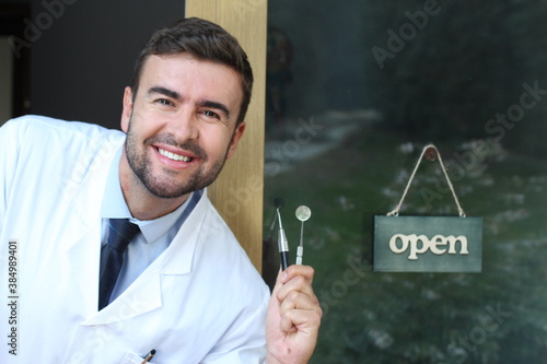 Cute dentist holding metallic tool 