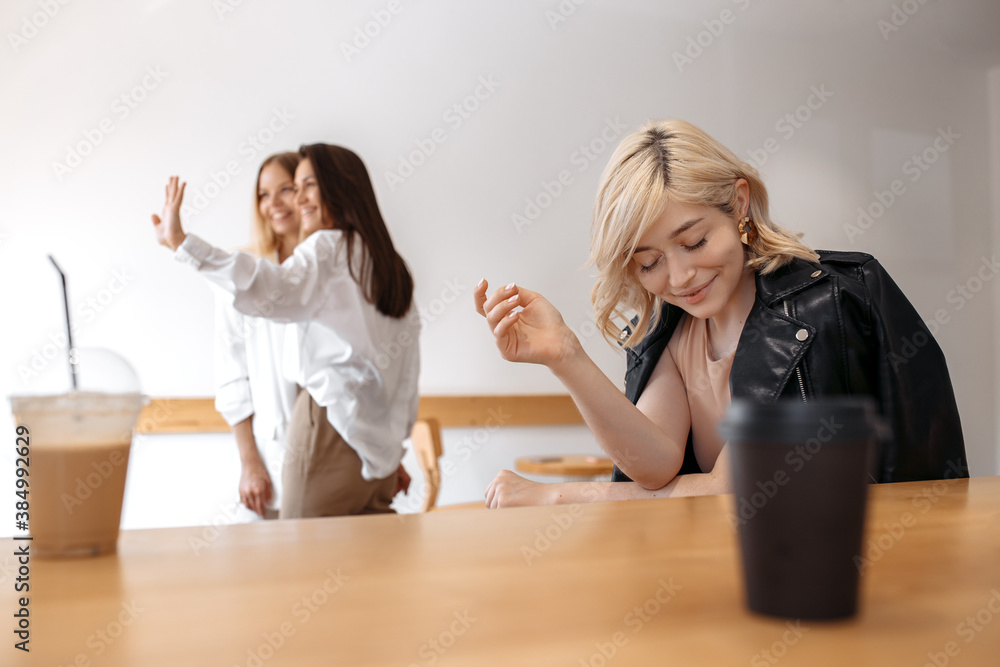 Pretty young women friends having coffee break while relaxing at the cafe indoors. Pretty young women friends having coffee break while relaxing at the cafe indoors.
