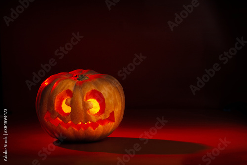 Halloween pumpkin with crazy face. Dark orange and red tones