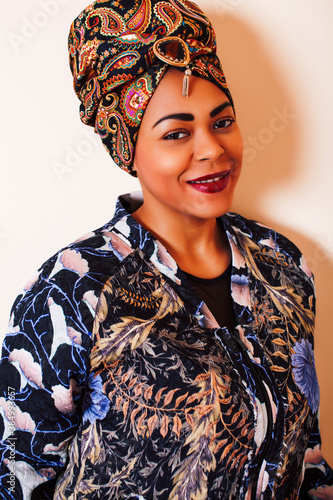 beauty bright african woman with creative make up, shawl on head like cubian closeup smiling photo