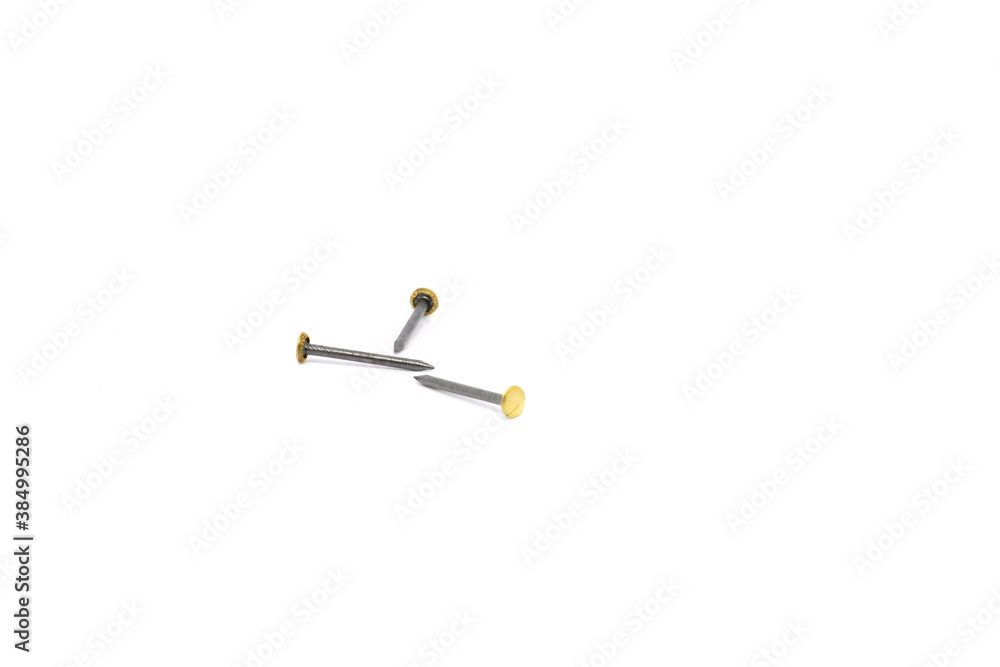 Three tacks on a white background. Three picture nails on a white background.Three gold-colored headed nails for frameworks on a white background. Three tacks on a white background. Three picture nails on a white background.Three gold-colored headed nails for frameworks on a white background.
