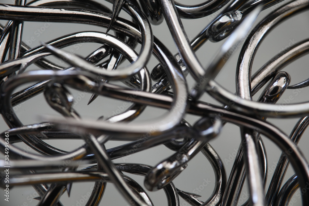 Lot of metal fishing hooks lie on table closeup. Sale of fishing tackle concept. Lot of metal fishing hooks lie on table closeup. Sale of fishing tackle concept.