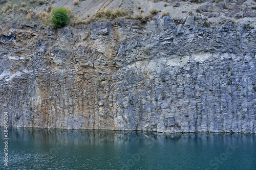 Lake in an ancient quarry with various types of rocks