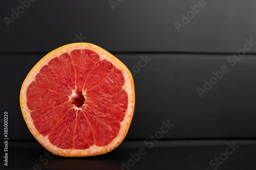 A slice of Grapefruit on a black background