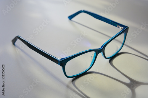 Rectangular glasses in bright blue frames close-up on a light background