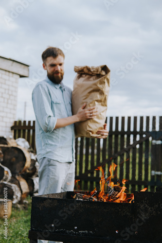 A man with a craft bag of charcoal in his hands. High quality photo