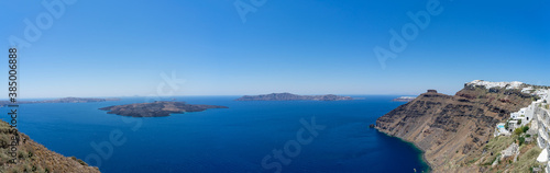 Fototapeta Naklejka Na Ścianę i Meble -  Beautiful panoramic view from Thira to caldera and volcano on a sunny day. Picturesque natural background with copy space for text. Santorini island, Cyclades, Greece, Europe.