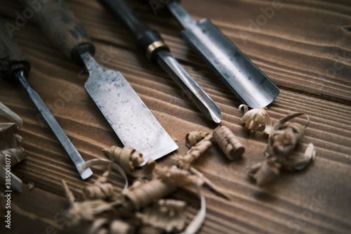 Close up view of a set of wood chisels for carving wood, sculpture tools on wooden background