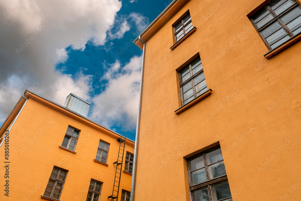 Orange industrial building with cloudy sky background