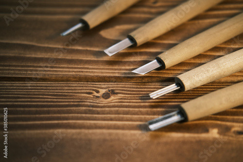 Close up view of a set of wood chisels for carving wood, sculpture tools on wooden background