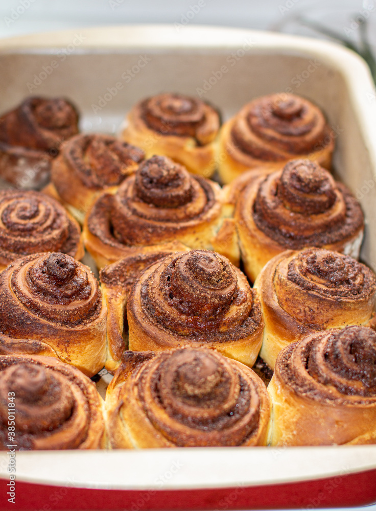 Delicious round cinnamon rolls on a baking sheet after the oven.