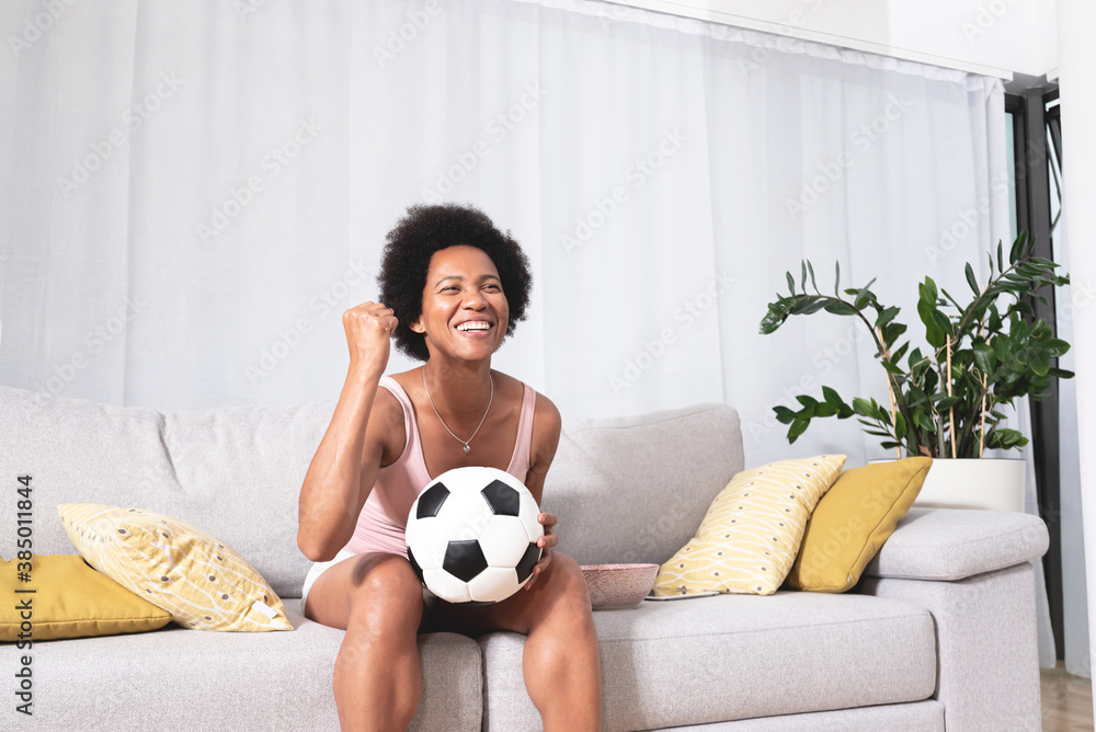 Female fan celebrating victory or goal watching television Female fan celebrating victory or goal watching television