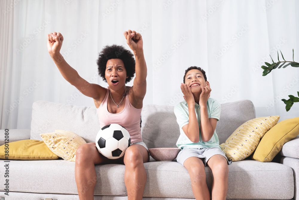 Excited mother and son watching soccer match at home Excited mother and son watching soccer match at home