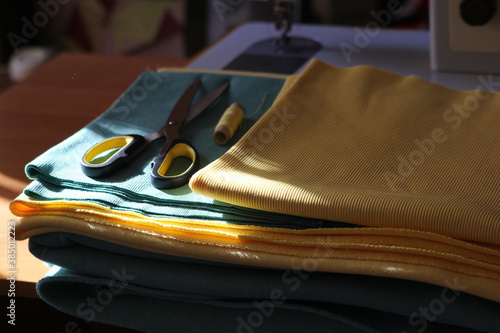 
fabrics and scissors with a spool of thread for atelier