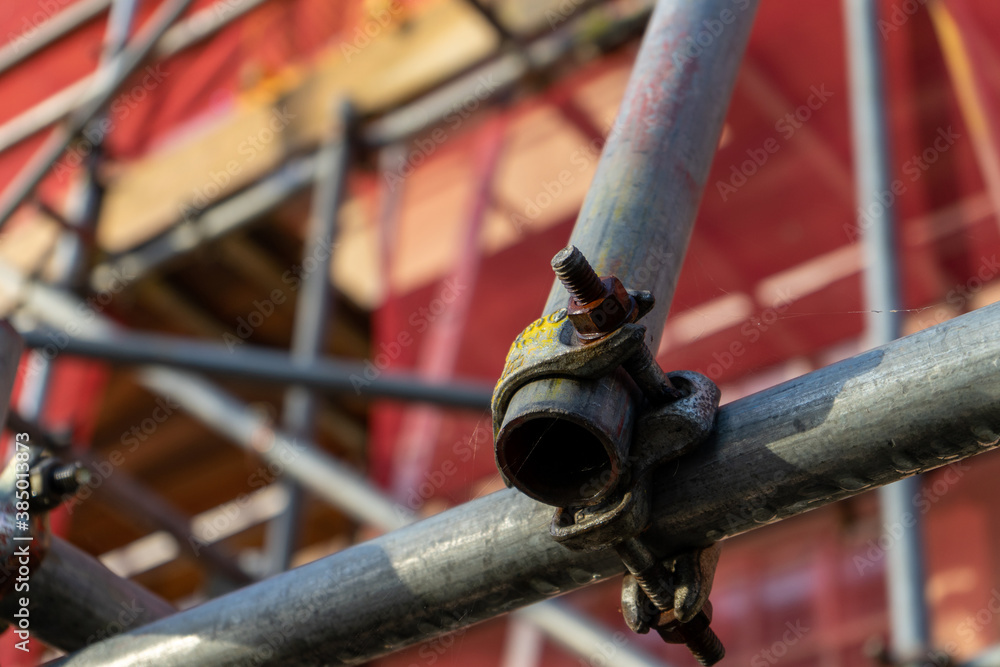A close up of scaffolding poles on the front of a building A close up of scaffolding poles on the front of a building