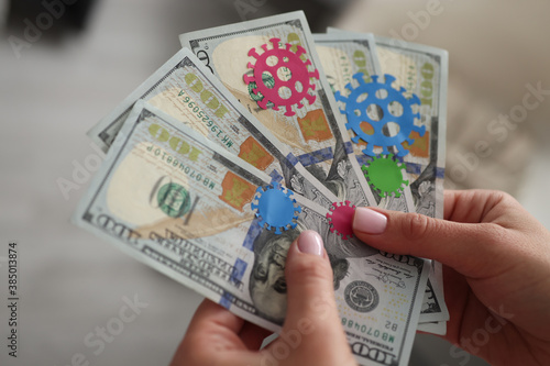 Female hands hold in hand dollar bills infected with coronavirus infection close-up. Cash as reason for spread of covid 19 concept.
