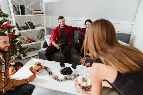 Image of joyful multinational friends eating pie and drinking wine photo