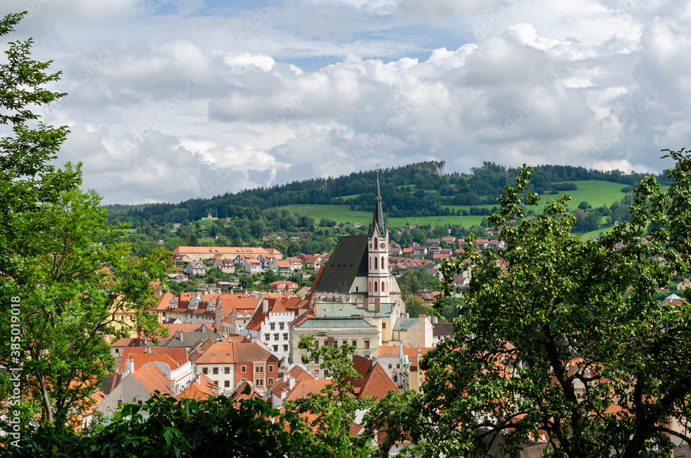 Horizontal Rooftop view of Cesky Krumlov and high St Vitus church, famous touristic old town in Czech Republic in summer.