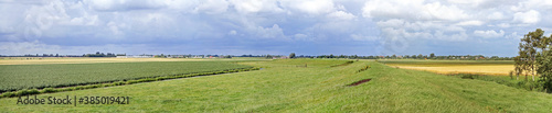 Fotografie Extremely flat polder landscape with a dike, in the Netherlands