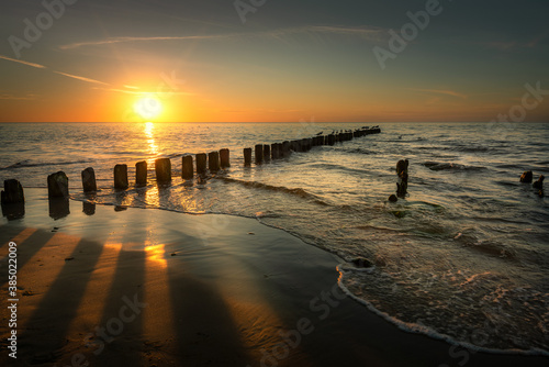 Baltic Sea seascape at sunset. Wooden breakwater