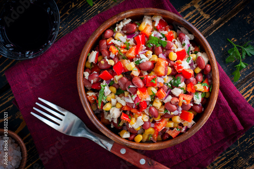 salad with red beans, corn and bell peppers in a wooden salad bowl, selective focus