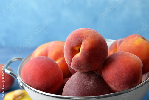 Sweet peaches in colander on table  closeup