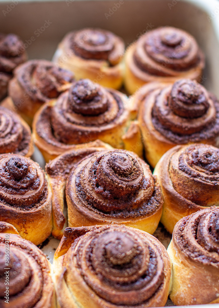 Delicious round cinnamon rolls on a baking sheet after the oven. Delicious round cinnamon rolls on a baking sheet after the oven.