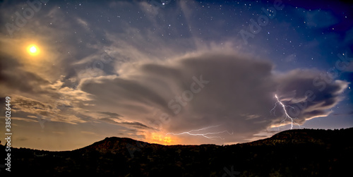 An isolated storm cell near Chino Valley being lit by the Moonlight during the summer monsoon season, Arizona
