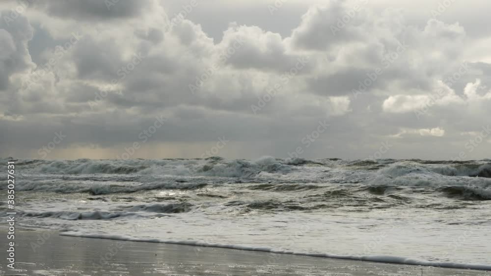 Grey clouds over the Baltic sea in Lithuania. Wind disperses the waves on the sea. Zoom in. Grey clouds over the Baltic sea in Lithuania. Wind disperses the waves on the sea. Zoom in.